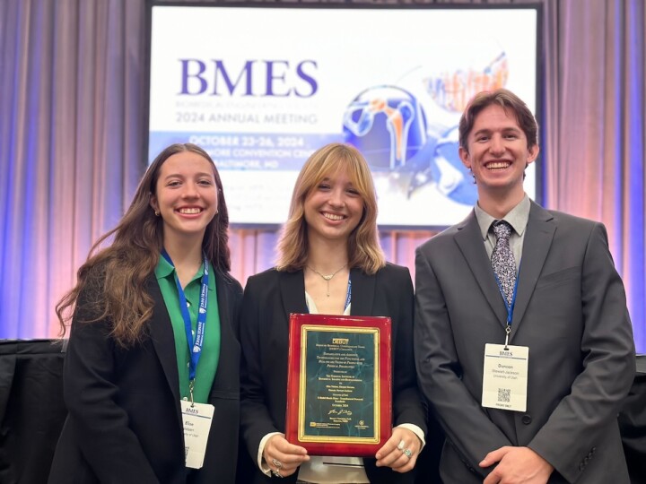 Elise Nielsen, Eleanor Stevens, and Duncan Stewart-Jackson pose with a plaque